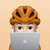 An emoji-style man wearing an orange bike helmet and AirPods, peeking over a MacBook on a light orange background.